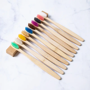 L'adulte mou coloré fait maison manipule les brosses à dents en bois en bambou